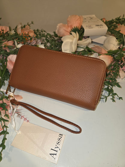 “Brown pebbled-texture zip-around wallet with matching wrist strap and gold-tone hardware, front view.”